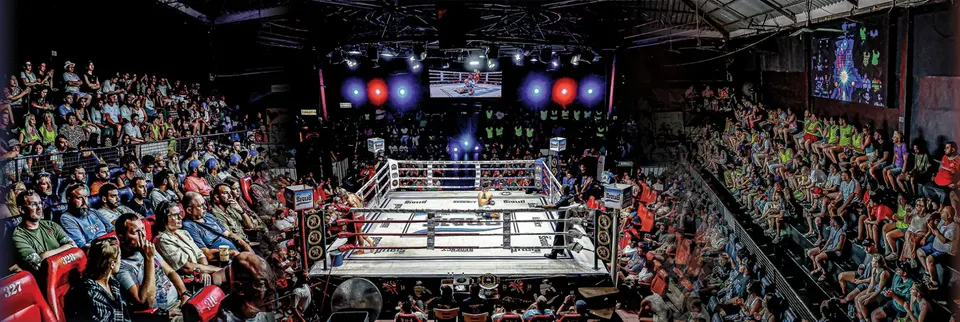 A packed Patong Boxing Stadium on fight night, with the crowd around the lit ring