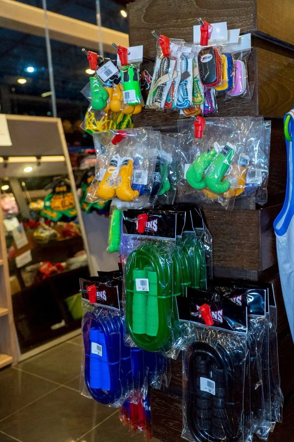 Mini boxing-glove keyrings and skipping ropes hanging on a display stand